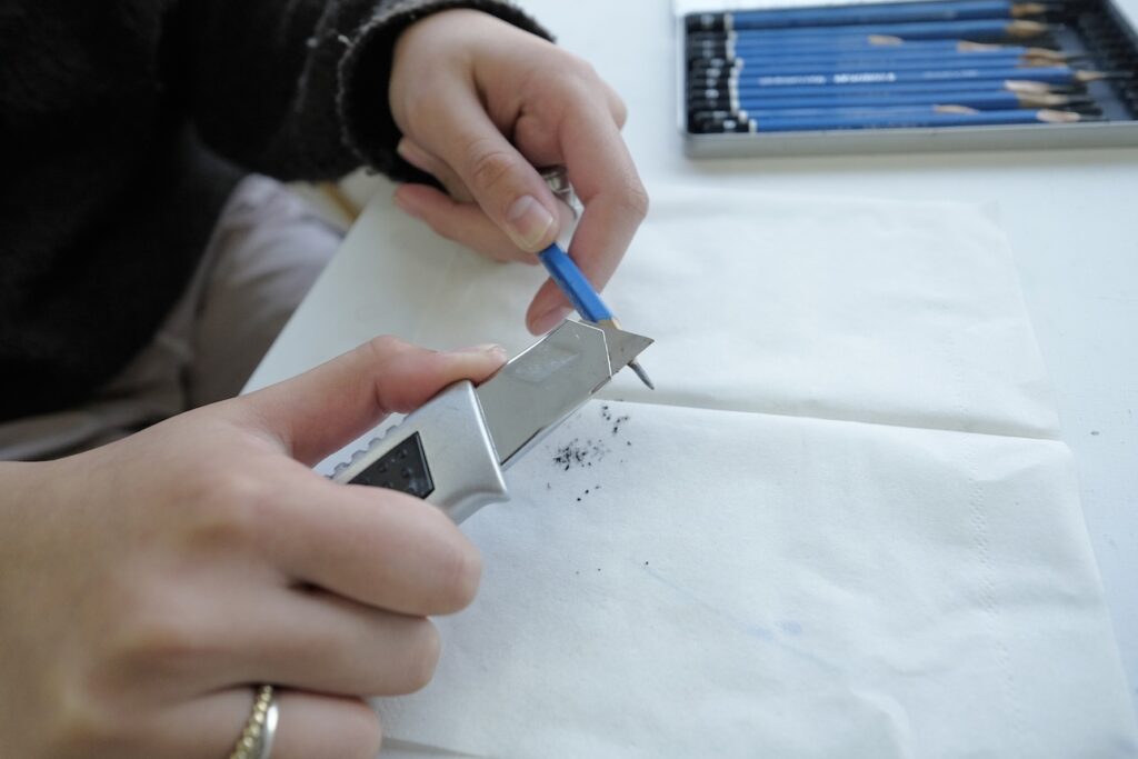 鉛筆を削っている女性の手